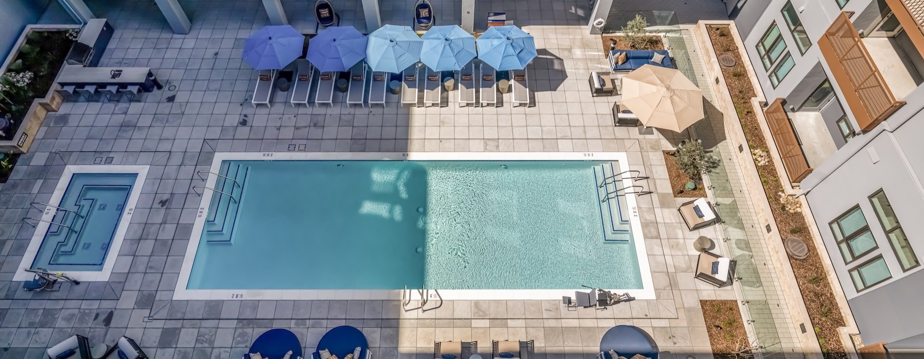 an aerial view of a swimming pool with umbrellas